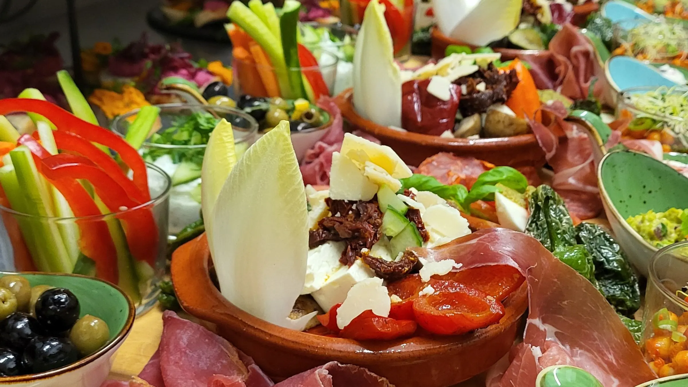 Antipasti-Brett mit Rohschinken, Chicorée, Tomaten und Käse