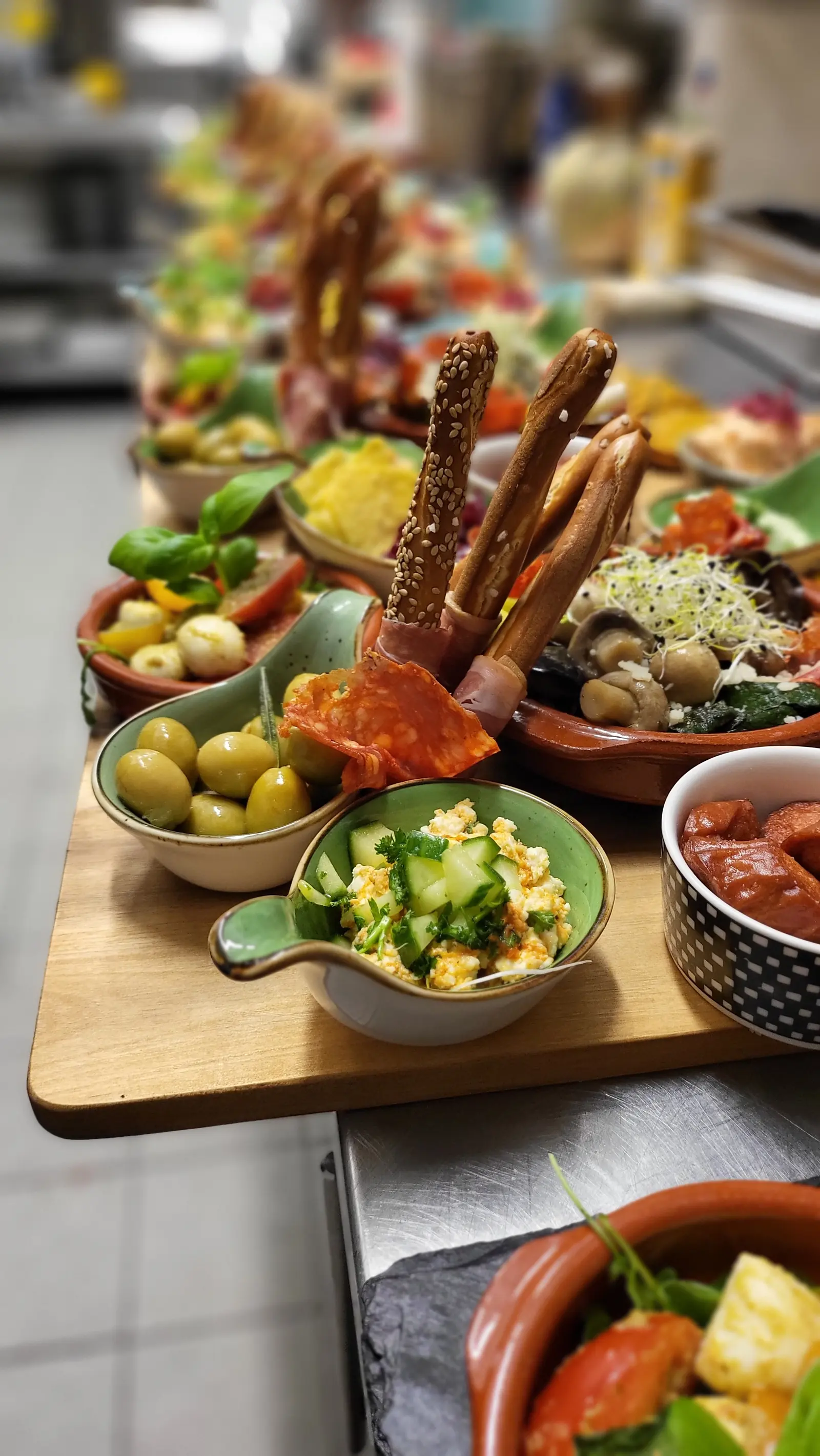 Vorspeisenbrett mit Oliven, Grissini, Dips und kleinen Schalen