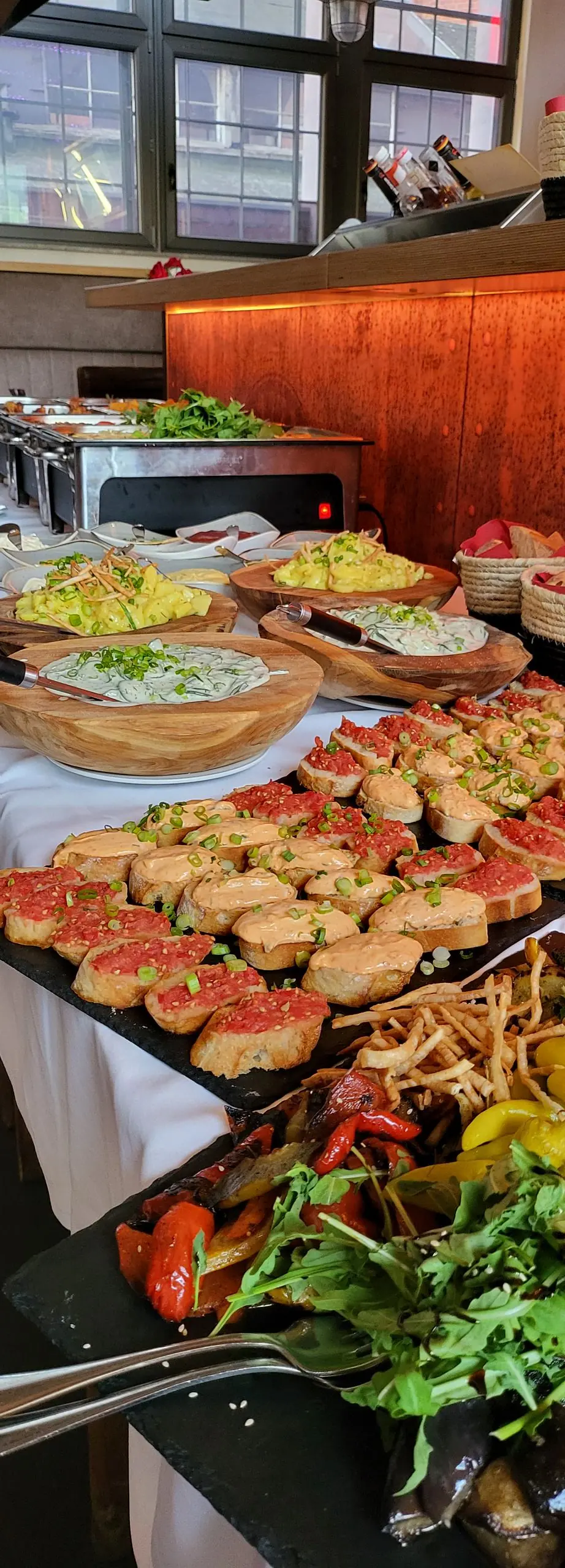 Buffet mit belegten Broten, Salatschüsseln und warmen Beilagen