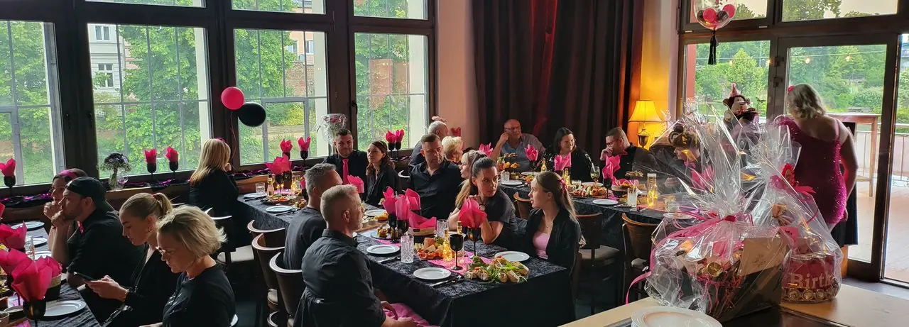 Gäste an festlich gedeckten Tischen bei einer Firmenveranstaltung